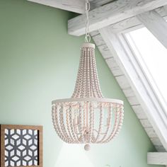 a white chandelier hanging from the ceiling in a room with mint green walls