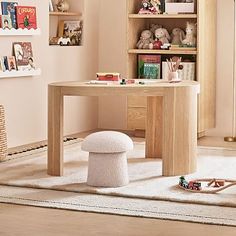 a child's desk and chair in a room with bookshelves, toys and stuffed animals