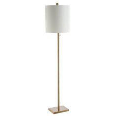 a floor lamp with a white shade on the base and a gold metal frame around it