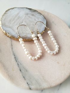 ∙These pearl hoop earrings are super femme and perfect for dressing up a simple outfit! Would also be wonderful for a bride with a bit of vintage flair. ∙Unique shape is sure to catch you some compliments. ∙Nice and lightweight on the ear! ∙Top quality materials are excellent for sensitive ears/skin. ∙These measure ~2.25 inches long. ~M A T E R I A L S ~ Choose from- * 925 Sterling silver *14k Gold fill *14k Rose gold fill **What is 14k Gold-fill?** Gold fill does not tarnish or wear off and con White Pearl Embellished Hoop Earrings For Wedding, Pearl Embellished Hoop Earrings For Wedding, Delicate White Hoop Earrings With Pearl Drop, Chic Pearl Embellished Earrings For Wedding, Chic Pearl Drop Bridal Earrings For Wedding, Chic Pearl White Pearl Earrings For Wedding, Chic Pearl White Earrings For Wedding, Pearl Chain Hoop Earrings For Wedding, Small Hoop Pearl Chain Wedding Jewelry