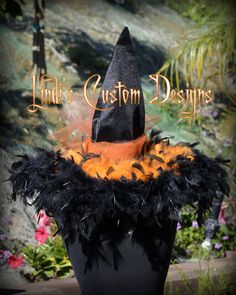 a black hat with orange feathers on it and the words ink's custom designs