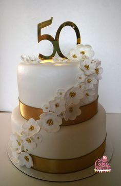 a white and gold cake with flowers on it