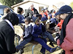 a group of people sitting on top of a wooden bench