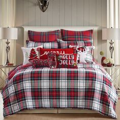 a red and white plaid comforter set with christmas decorations on the pillowcases