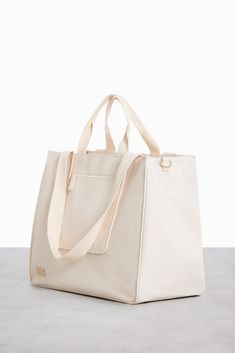 The East To West Tote in Beige White Laptop Bag With Sleeve For Travel, Functional Beige Tote Diaper Bag, Weekend Diaper Bag Tote With Removable Pouch, Weekend Diaper Tote With Removable Pouch, Diaper Tote Bag With Removable Pouch For Weekend, Cream Rectangular Travel Diaper Bag, Cream Bag With Luggage Sleeve For Everyday, Everyday Cream Bag With Luggage Sleeve, Cream Rectangular Diaper Bag For Travel