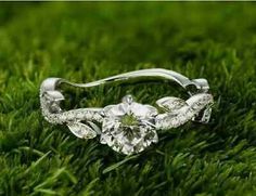 a diamond ring sitting on top of green grass