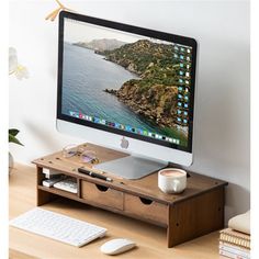 a desktop computer monitor sitting on top of a wooden desk next to a keyboard and mouse