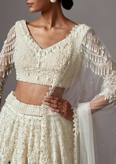 Embroidered lehenga with pearls and silver embellishments paired with a beaded blouse and dupatta. Ivory Lehenga, Heavy Necklace, Latest Bridal Lehenga, Embroidered Lehenga, Beaded Blouse, Western Wedding, Wedding Service, Fashion App, Bridal Lehenga