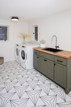 a washer and dryer in a room with geometric floor tiles on the floor