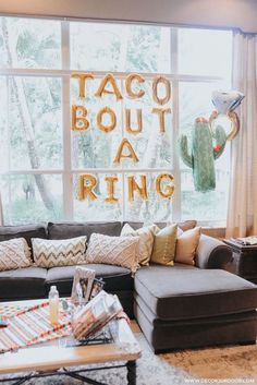 a living room filled with lots of furniture next to a large window that says taco bouta ring