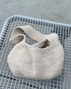 a knitted bag sitting on top of a metal grate