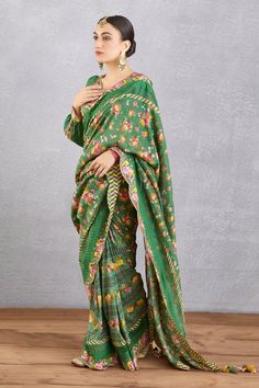 Emerald green saree blouse with all-over floral motifs, cutwork detail, tassel tie-ups and plunging neck.
Component: 1
Printed
Neckline: V Neck
Sleeve Length: Long
Fabric: Handwoven Chanderi, cotton silk
Color: Green
Plunging neck
Cutwork detail
Cuff sleeves
Note: Saree worn by the model is not for sale
 - Aza Fashions Green Blouse Piece For Spring, Unstitched Green Saree Blouse, Green Cotton Silk Saree Blouse, Green Cotton Silk Blouse With Dupatta, Festive Green V-neck Blouse Piece, Spring Long Sleeve Green Blouse Piece, Festive Spring Green Blouse, Festive Green Spring Blouse, Green Unstitched Cotton Blouse Piece