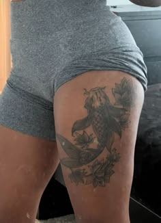 a woman with a fish tattoo on her thigh