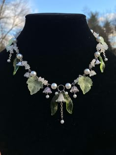 This necklace is dedicated to the beauty of nature. The glass pearl beads add an elegancy to the piece and pairs well with the natural moonstone chip beads. The flower beads are a mix of acrylic and glass as well as the leaves. This whimsical necklace is put together with stainless steel head pins, eye pins and jump rings and comes with an extender chain and lobster claw. Can also be made with 18k plated gold or rose gold. Lily Of The Valley Crown, Beaded Leaf Necklace, Necklace Beaded Ideas, Gold Handmade Jewelry, Whimsical Jewelry Diy, Lily Of The Valley Necklace, Crystal Art Crafts, Necklace Designs Beads, Witch Jewelry Diy