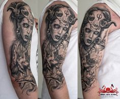 a woman's arm and shoulder covered in black ink with an image of a demon