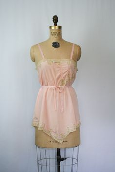 "Vintage 1920s pink silk crepe embroidered floral lace chemise Beautiful lace inset neckline with a sweet ribbon flower Pick stitch embroidery detail on front bust line and more beautiful lace Lace trimmed hem Fabric tie that is attached at back waist and can be worn tied around waist or in a simple bow at back Silk ribbon straps Crotch has been undone so it can be worn as a camisole Pull on MEASUREMENTS: taken flat Fits like a Small Bust: up to 36\" Waist: up to 38\" Hips: up to 46\" Strap Leng Simple Bow, Pick Stitch, Silk Chemise, Silk Romper, Lace Chemise, Pink Party Dresses, Lace Trim Dress, Ribbon Flower, Lace Inset