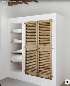 an open wooden shutter in a white room