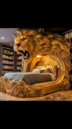 a bed with a lion head on top of it in front of a bookshelf