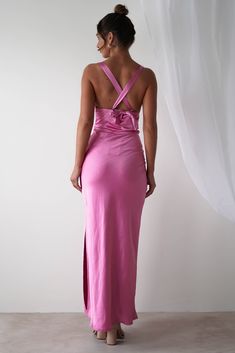 a woman in a pink dress looking back