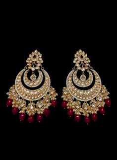 Neetri - Kundan Earrings with Ruby drops Graceful traditional Indian earrings made with hammered metal and plated with gold. This glamourous Kundan stone stud setting makes this earring jewelry one of a kind. Red Ruby gems add color and grace to this jewelry piece. Luxurious pearl drops enhance this piece making it perfect to be paired with any of your ethnic wear. Approximate earrings 3.5" Details: Handcrafted Metal: Metal Alloy, Gold Plated Stone: Kundan, Pearls & Ruby's Traditional / Mode Luxury Meenakari Bridal Earrings For Reception, Luxury Ruby Meenakari Jhumkas, Luxury Earrings For Anniversary And Diwali, Luxury Bollywood Earrings For Navratri, Luxury Traditional Ruby Jhumkas, Red Pearl Earrings, Bollywood Style Red Jewelry With Matching Earrings, Traditional Red Gold-plated Bridal Earrings, Elegant Ruby Chandbali Danglers