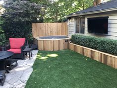 a backyard with a hot tub and patio furniture in the back yard, surrounded by grass