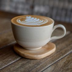 there is a coffee cup that has been decorated with white designs on the top and bottom