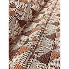 a brown and white rug on top of a wooden floor