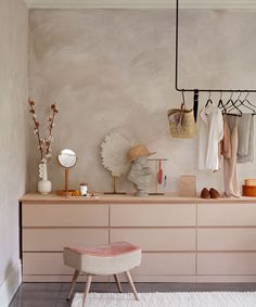 a room with a dresser, stool and various items on the shelves in front of it