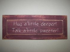 a wooden sign that says hug a little deeper talk a little sweeter