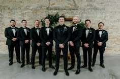 a group of men standing next to each other in tuxedos and bow ties