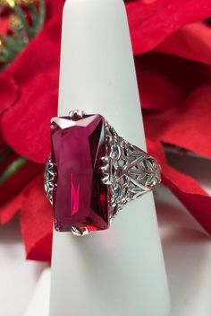 Simulated Ruby Ring Description Intaglio Design#31 MADE TO ORDER Inspired by the intricate Victorian designs of the late 1800s, I now offer this gorgeous filigree Antique reproduction in sterling silver. The lovely ring is set with a flawless 7ct simulated red ruby. The baguette rectangle-cut red ruby color gem is 18mm long by 9mm wide. The ring is 8mm off the finger. The inside of the band is marked 925 for sterling. Notice the intricate and detailed design of the silver filigree setting and ba Classic Red Ruby Jewelry, Formal Octagon Ruby Jewelry, Classic Ruby Ring For Valentine's Day, Classic Red Jewelry With Lab-created Ruby, Red Jewelry With Accent Stones For Formal Occasions, Classic Red Lab-created Ruby Jewelry, Valentine's Day Classic Ruby Ring, Classic Red Gemstone Jewelry, Red Ruby Filigree Ring For Wedding