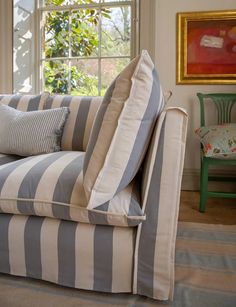 a striped couch sitting in front of a window