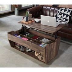 a coffee table with an open drawer underneath it and a laptop computer on the top