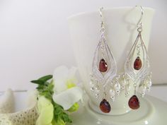 Garnet faceted teardrops are hung on fabulous handcrafted drops of Sterling Silver. Just right for that special holiday dress or even your favorite jeans when you need a little pick me up. These show stoppers will be noticed! Garnet is the official birthstone of January. The deep, glossy red color of garnet so resembles the juicy seeds of a pomegranate, that its name is derived from the Latin word for pomegranate seeds, granatum. In Greek mythology, a pomegranate was often given as a gift of pas Teardrop Chandelier Earrings With Dangling Beads As A Gift, Teardrop Chandelier Earrings With Dangling Beads For Gift, Handmade Teardrop Chandelier Earrings For Anniversary, Gemstone Teardrop Earrings For Wedding, Gemstone Teardrop Dangle Earrings For Wedding, Gemstone Dangle Teardrop Earrings For Wedding, Dangle Teardrop Gemstone Earrings For Wedding, Wedding Gemstone Teardrop Dangle Earrings, Wedding Gemstone Teardrop Earrings