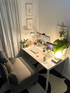 a desk with a computer and plants on it