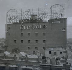 an old gold sign is on the side of a building that's under construction