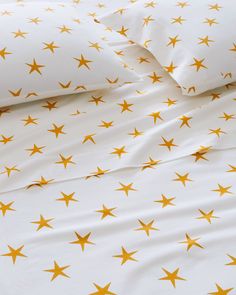 a bed with yellow stars on it and white sheets