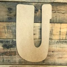 the letter u is made out of cardboard and sits on a wooden surface with wood planks