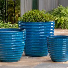 three large blue planters sitting next to each other