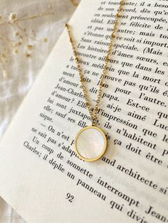 Mother of pearl round Gold coin dangling from a satellite chain with lobster clasp and extension chain. Circular Pearl Pendant Jewelry Gift, Round Pearl Pendant Necklace, Vintage Round Necklace With Pearl Charm, Classic Gold Necklace With Mother Of Pearl, Vintage Tarnish Resistant Necklace, White Medallion Necklace With Coin Pendant, White Coin Pendant Medallion Necklace, White Medallion Coin Pendant Necklace, Yellow Gold Coin Necklace With Pearl Pendant