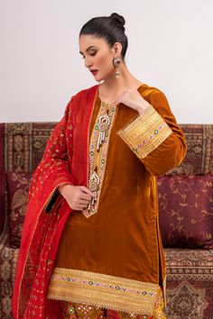 A traditional style suit in velvet with gota work on the neck and hem with handmade motifs on the neckline. Paired with a tailored shalwar and an emroidered organza dupatta for a sophisticated look.3-piece suitReady-to-wear Elegant Velvet Kurta With Mirror Work, Traditional Lawn Suit With Mirror Work, Designer Velvet Kurta With Mirror Work, Gold Salwar Kameez With Embroidered Border For Designer Wear, Traditional Lawn Suit With Mirror Work In Dola Silk, Traditional Festive Lawn Suit With Mirror Work, Traditional Raw Silk Lawn Suit With Mirror Work, Designer Velvet Kurta With Dabka Detailing, Velvet Kurta With Mirror Work And Traditional Drape