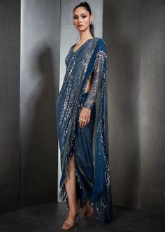 Our draped sari has metallic fringes. Paired with a one-shoulder, cord embroidered blouse. Perfect for a sangeet/ reception. Festive Embroidered Blue Pre-draped Saree, Luxury Embroidered Blue Pre-draped Saree, Fitted Embellished Blue Pre-draped Saree, Blue Bollywood Embellished Pre-draped Saree, Blue Embellished Semi-stitched Pre-draped Saree, Blue Drapes, Embroidered Blouse, One Shoulder, Blue