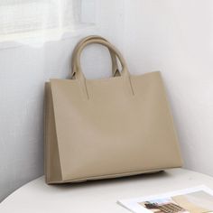 Looking to give your business style a modern update? Consider choosing this stylish women's tote bag. With its vertical square shape, it exudes elegance and sophistication. Crafted from genuine leather, it offers both durability and a touch of luxury. The solid pattern adds a sleek and professional touch, while the large capacity ensures ample space for all your essentials. Upgrade your style and make a statement with this fashionable and functional handbag.Specifications With/without interlining: Yes Texture: Cowhide Style 2: Fashion Trend Style: Shoulder Bag Style: Business Size: Medium Shoulder Strap Style: Single Root Shape: Satchels Shape: Verticle square Popular Style Name: Tote Bag Popular Elements: Contrast Color Place Of Origin: GUANG DONG Province Pattern Type: Solid Pattern: Sol