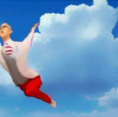 a man flying through the air on top of a blue cloudy sky next to a white cloud