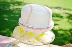 a baseball themed cake on a table with other desserts and snacks in the background