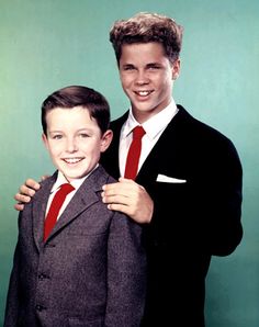 two young men in suits posing for a photo