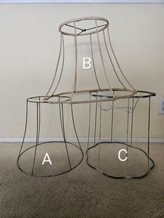 two metal lampshades sitting on top of each other in front of a wall