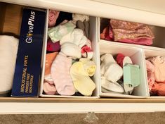 an open drawer with clothes in it and a book on the shelf next to it