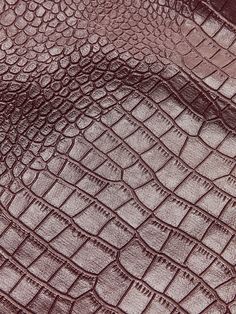 the texture of an alligator skin is shown in this close up photo, with dark brown tones