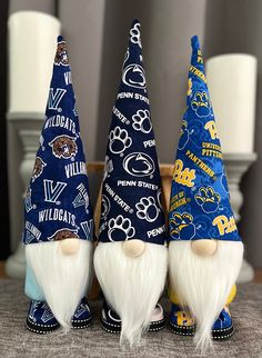 three blue and white gnomes sitting next to each other on top of a table